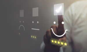 Main sélectionne une évaluation cinq étoiles avec une icône de visage souriant, illustrant la satisfaction client et l’importance de l’expérience utilisateur pour préserver la marge en période de crise