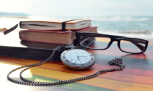 Lunettes, livres et l'horloge sur une table pour comprendre pourquoi c'est le bon moment pour commercialiser.
